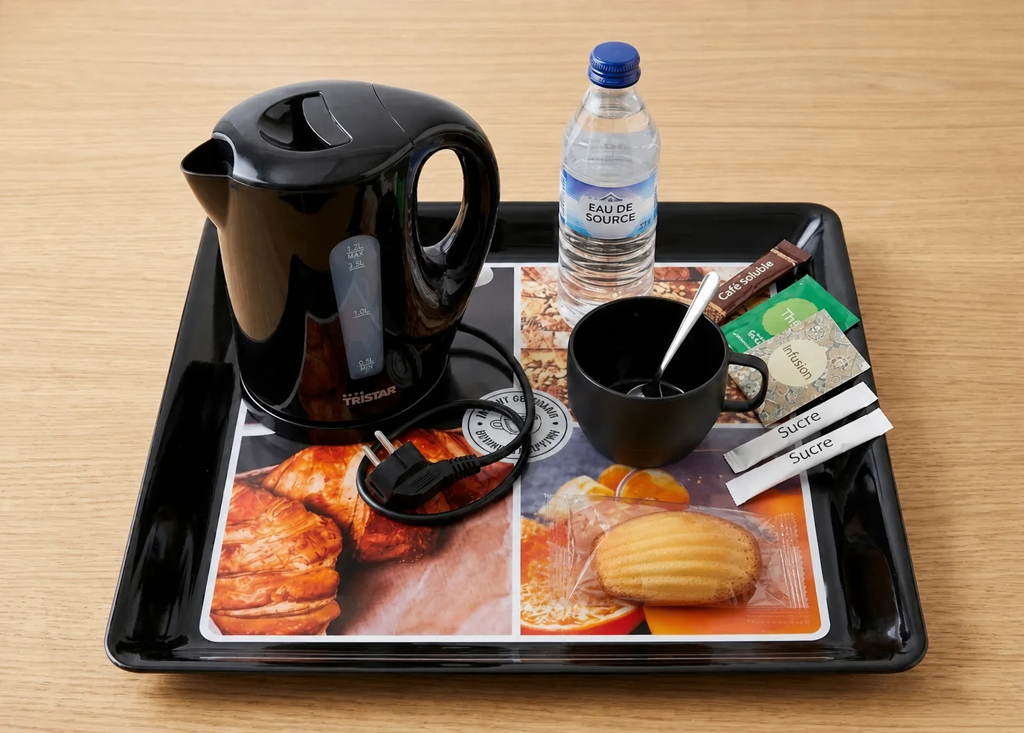 Plateau de courtoisie en chambre avec bouilloire, boissons chaudes, eau et gourmandise